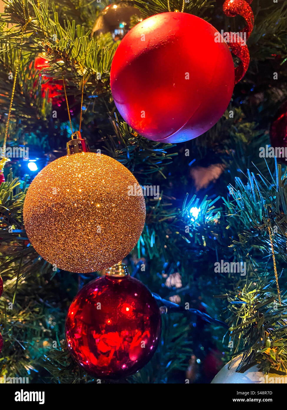 Goldene und rote Kugeln auf dem Weihnachtsbaum. Stockfoto