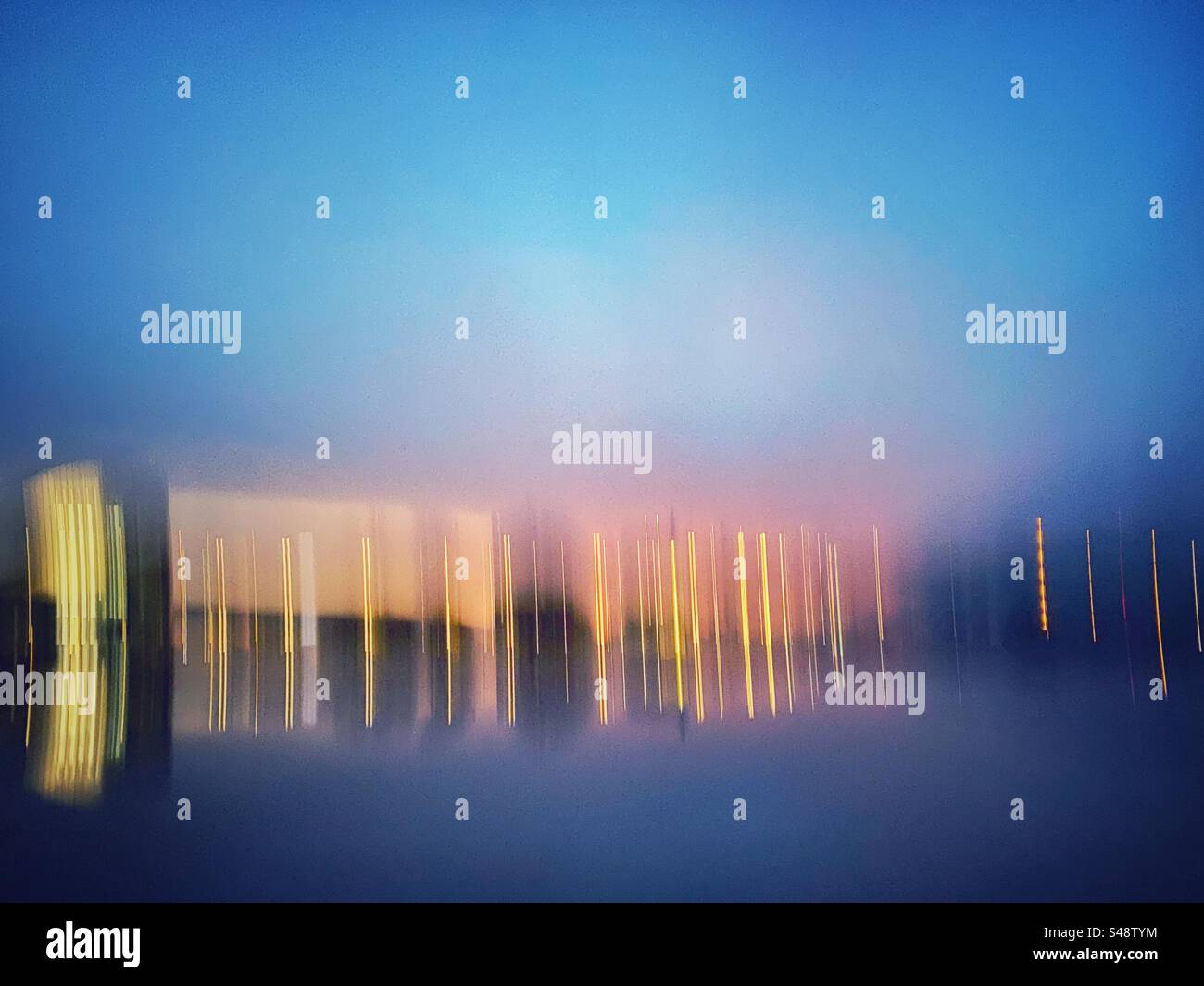 Eine Langzeitbelichtung mit Lichtmalerei von Außenlichtern, die sich im Wasser reflektieren. Bewegung und Bewegung, abstrakte Hintergrundstruktur. - Smartphone-aufgenommenes Stockfoto