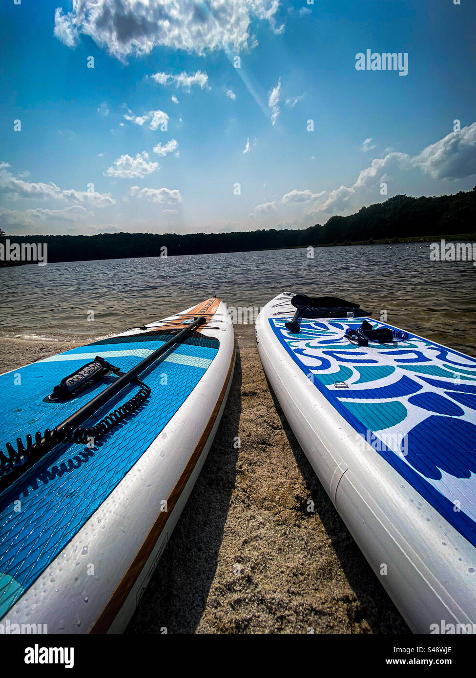 Aufblasbares Paddleboard am Strand am See Stockfoto