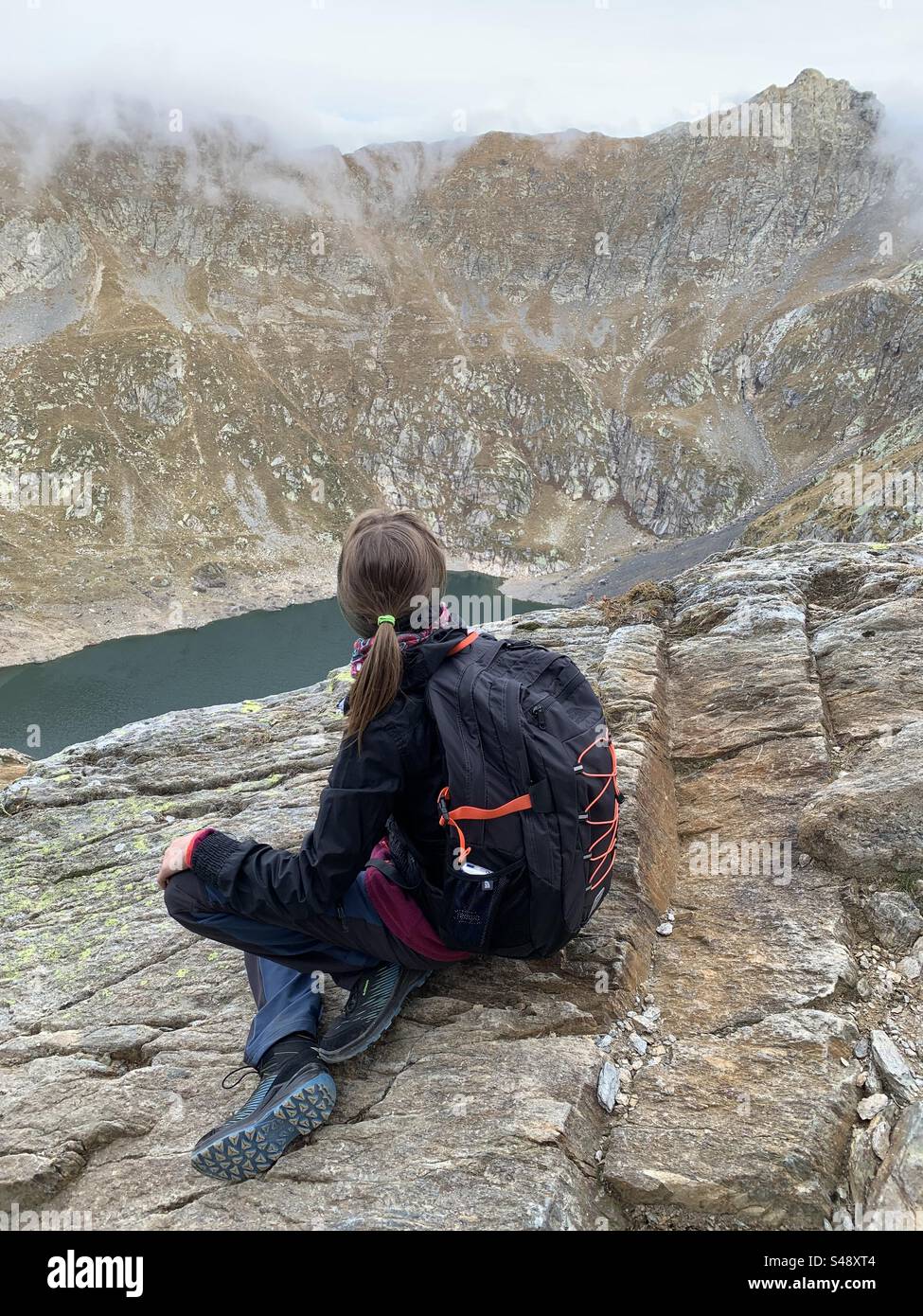 Ragazza guarda dall’alto il Lago del Diavolo. Carona, Italien. Stockfoto