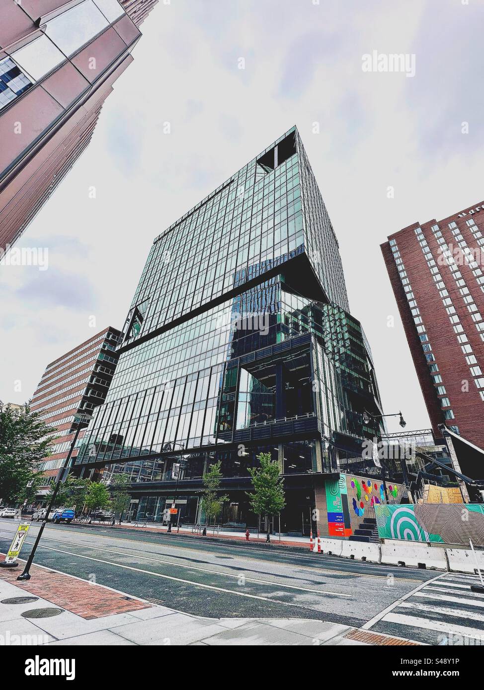 Cambridge, Massachusetts, USA: Modernes Glasgebäude am Kendall Square als Straßenszene nach dem Regen. Stadtbild mit Weitwinkelobjektiv. - Smartphone-aufgenommenes Stockfoto