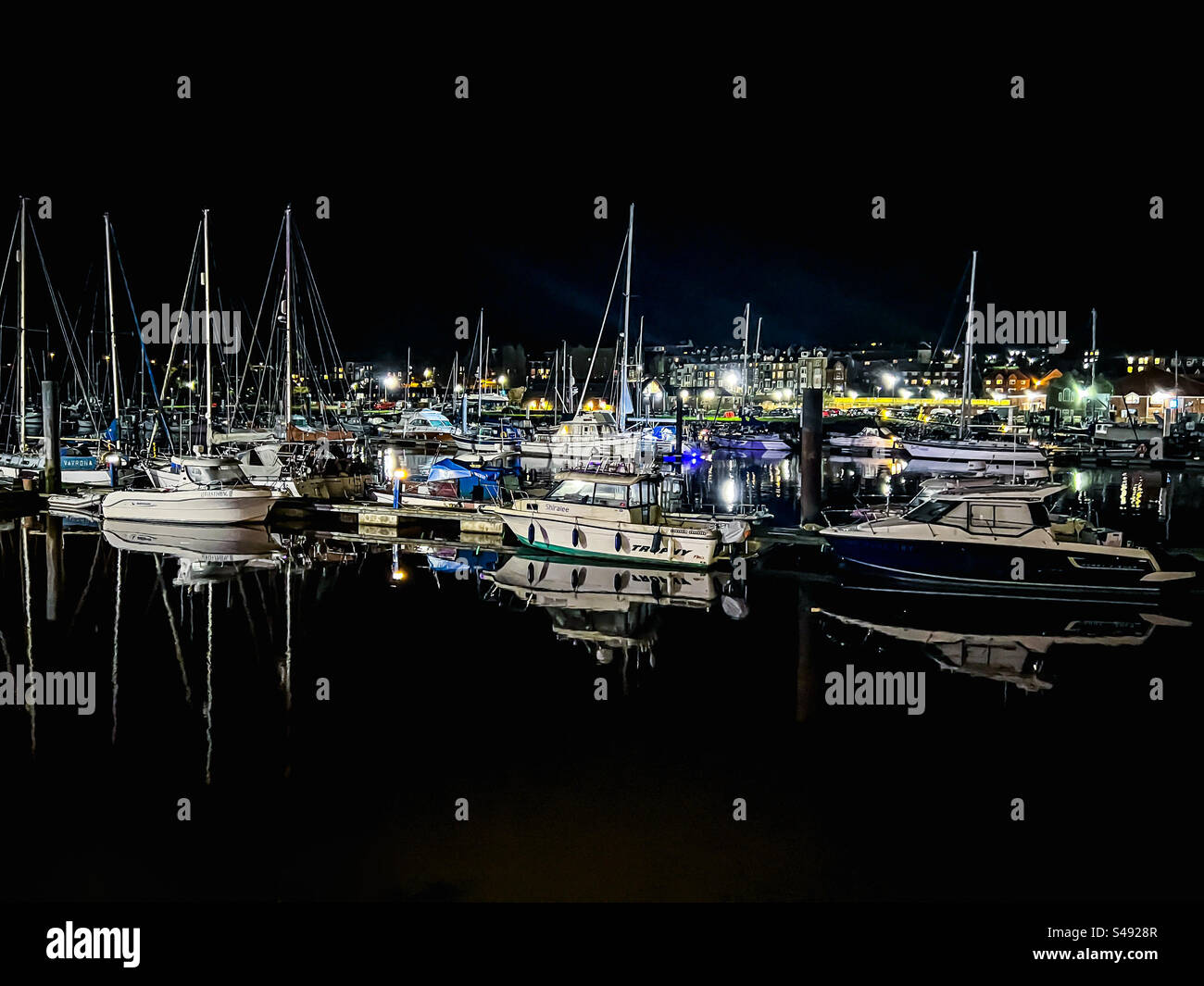 Boote und Segelschiffe auf dem Fluss Esk in Whitby während der dunklen Nacht Stockfoto