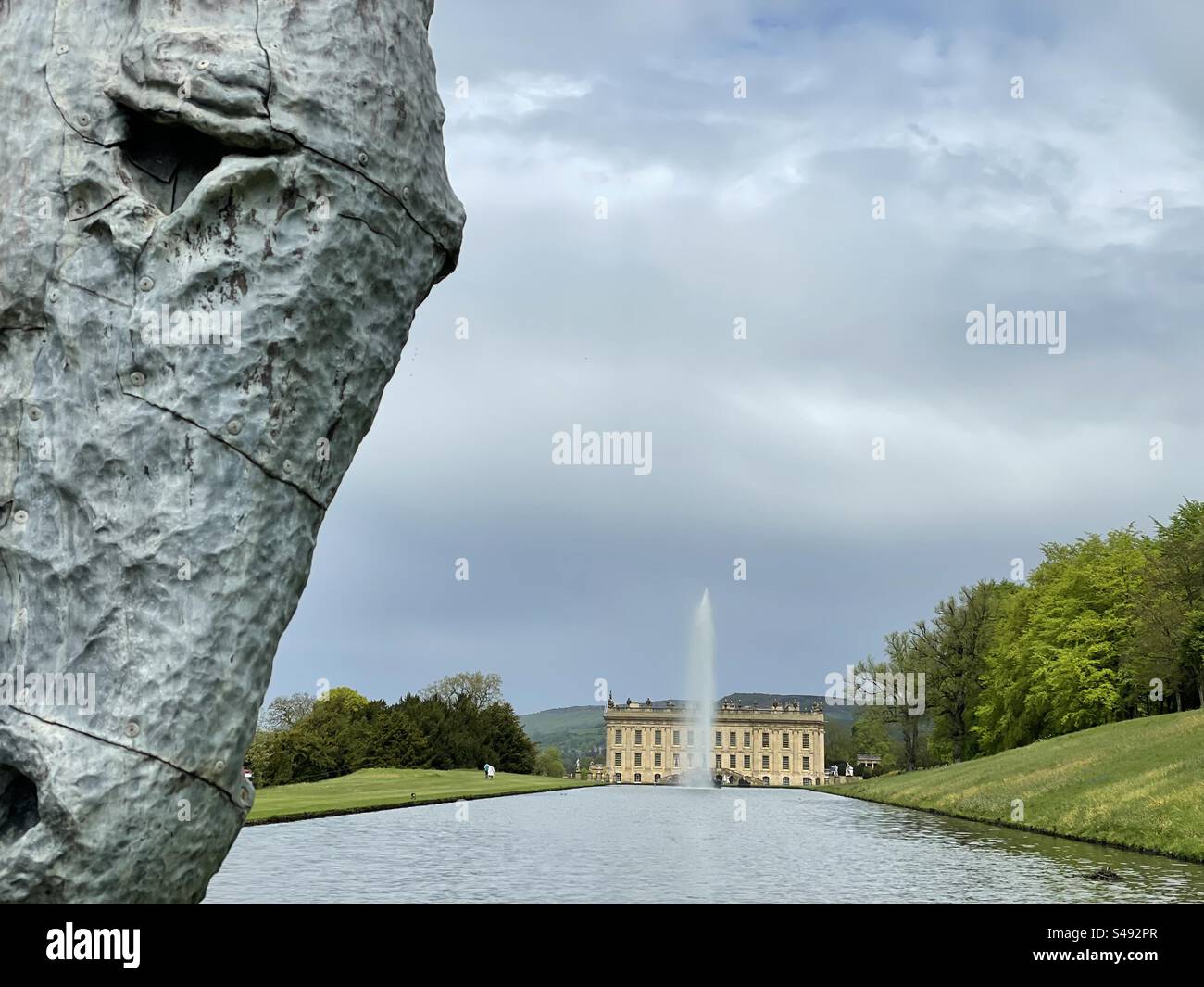 Eine Pferdestatue mit Blick auf das Chatsworth House im Hintergrund - Smartphone-aufgenommenes Stockfoto