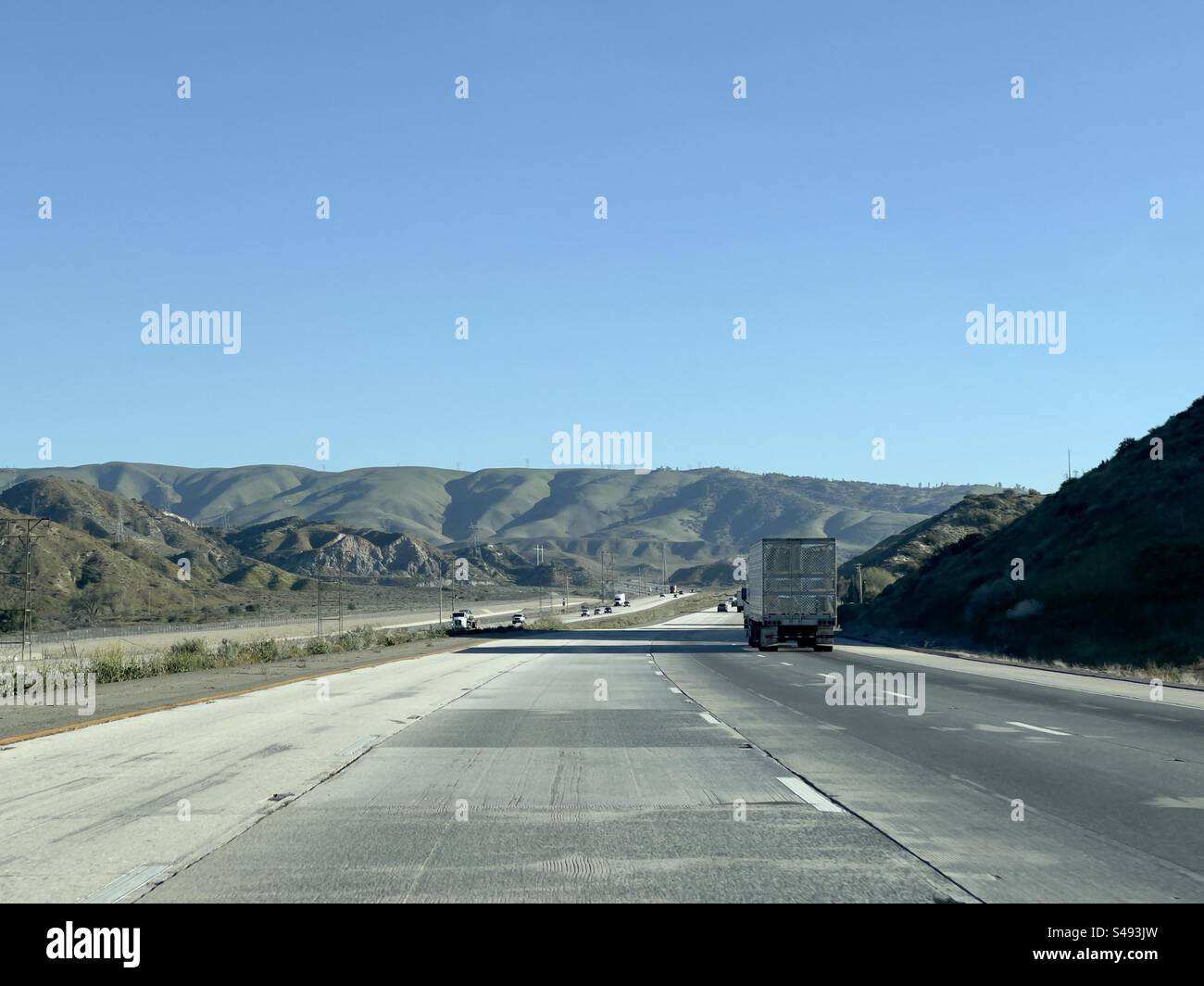 Lkw und Autos fahren auf dem Freeway durch die Berge im Süden Kaliforniens, USA Stockfoto