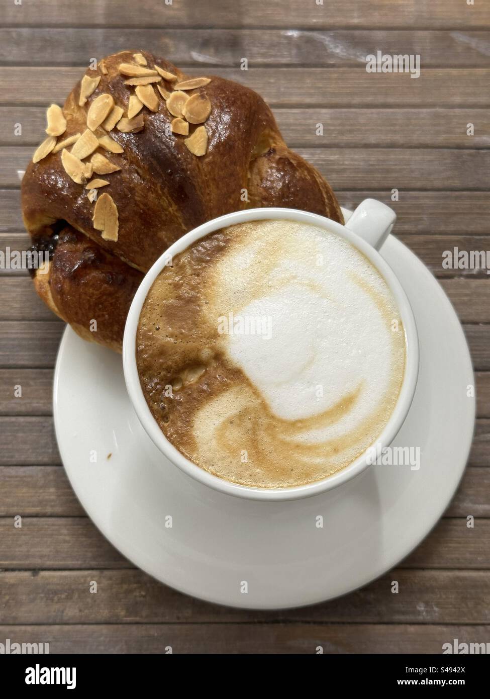 Leckeres Frühstück an der Bar mit Cappuccino und Croissant Stockfoto