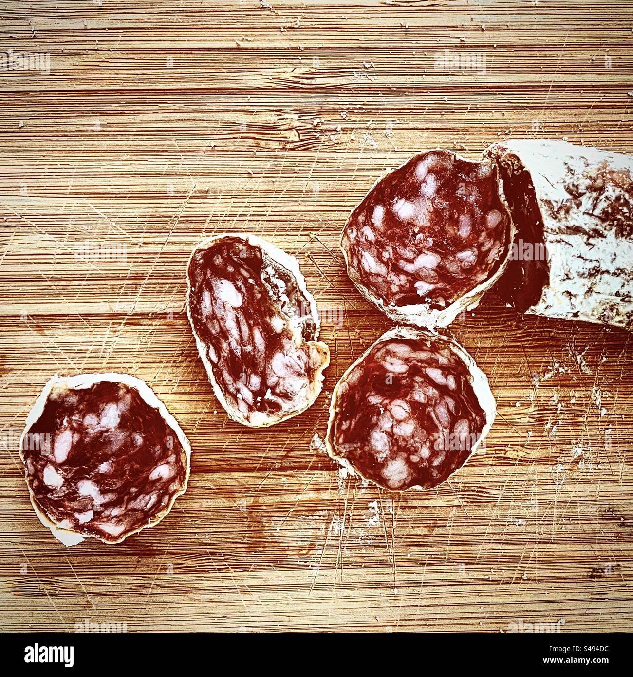 Salamischeiben trocken gesalzene Würstchen Saucisson Foid auf weißem Holzbrett in der Küche bereit zum Essen essen essen essen Stockfoto