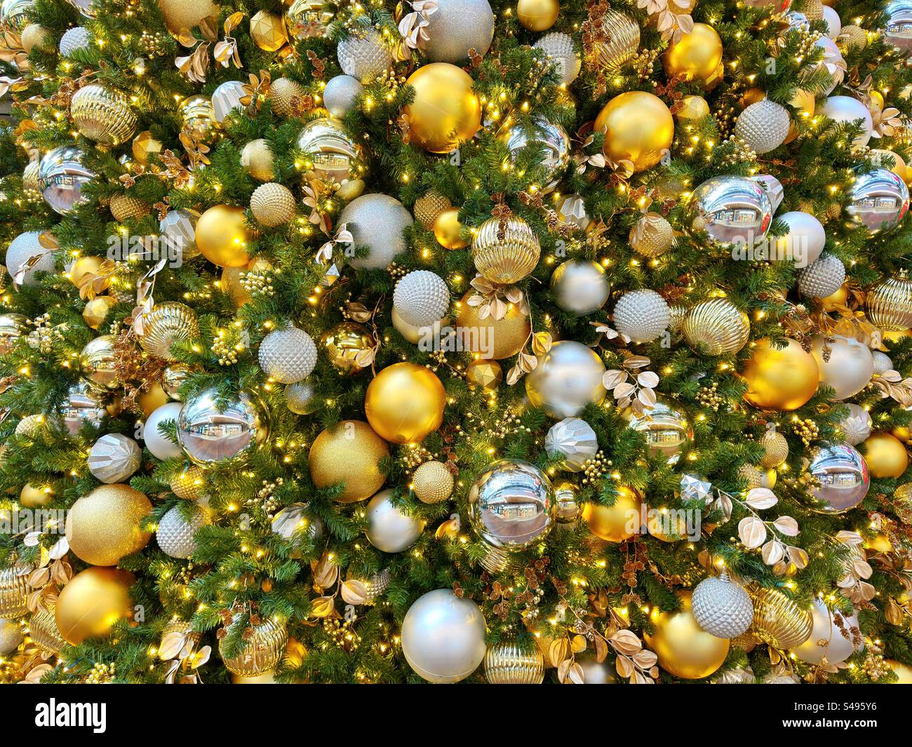 Goldene und silberne Weihnachtsdekorationen auf einem Baum - Smartphone-aufgenommenes Stockfoto