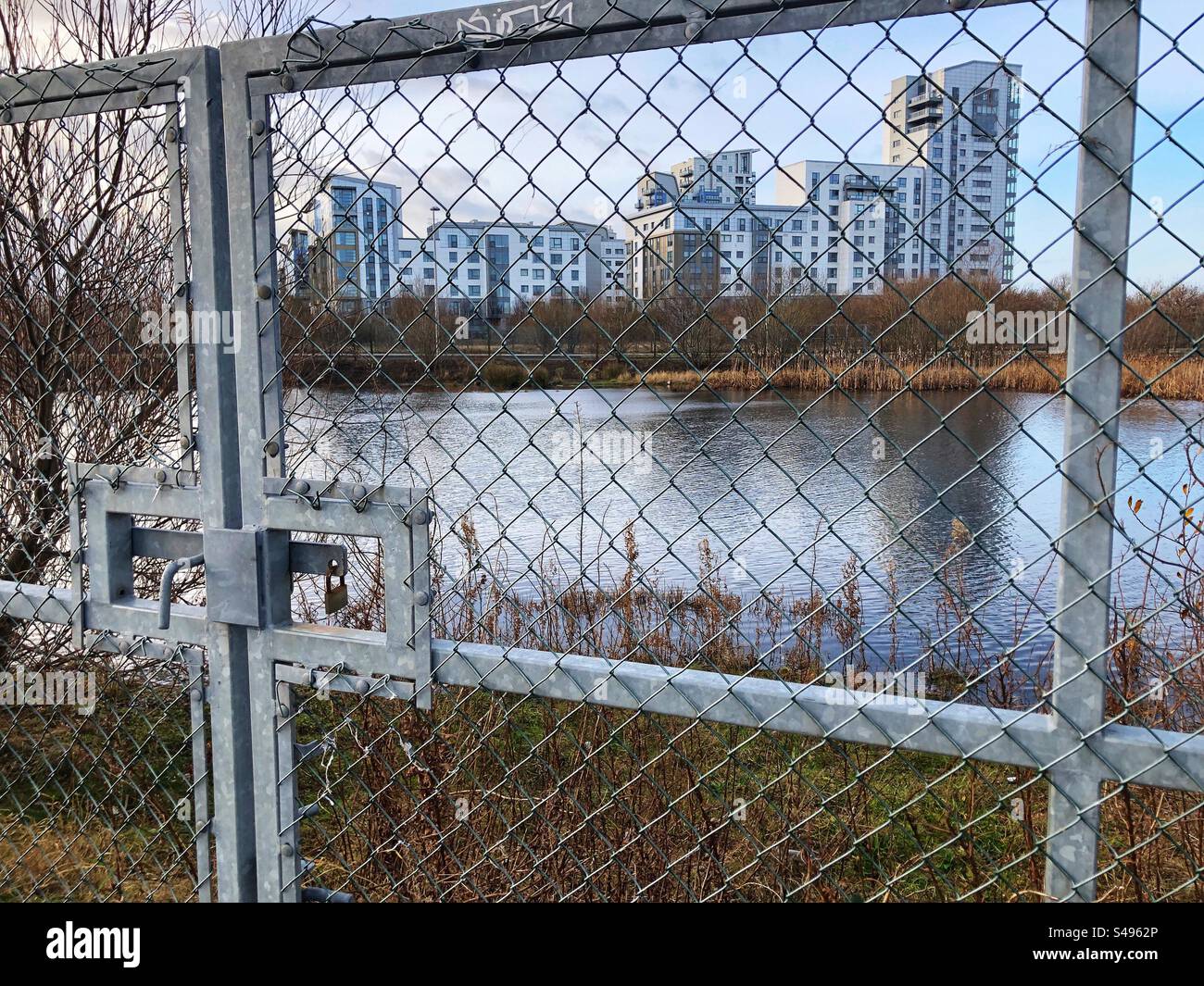 Moderne Stadtentwicklung durch verschlossene Tore und Drahtzaun, Leith Edinburgh, Schottland - Smartphone-aufgenommenes Stockfoto