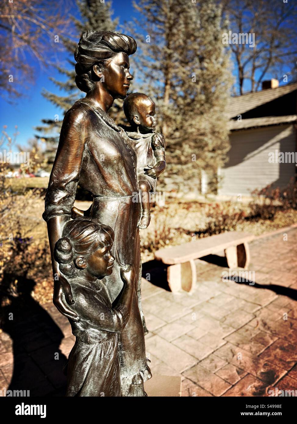 Skulptur einer Frau mit zwei Kindern. Das Kind in einem Arm halten und das Mädchen an ihrer Seite festhalten, das ihren Rock hält. Statue in Frederick, Colorado, USA. Stockfoto