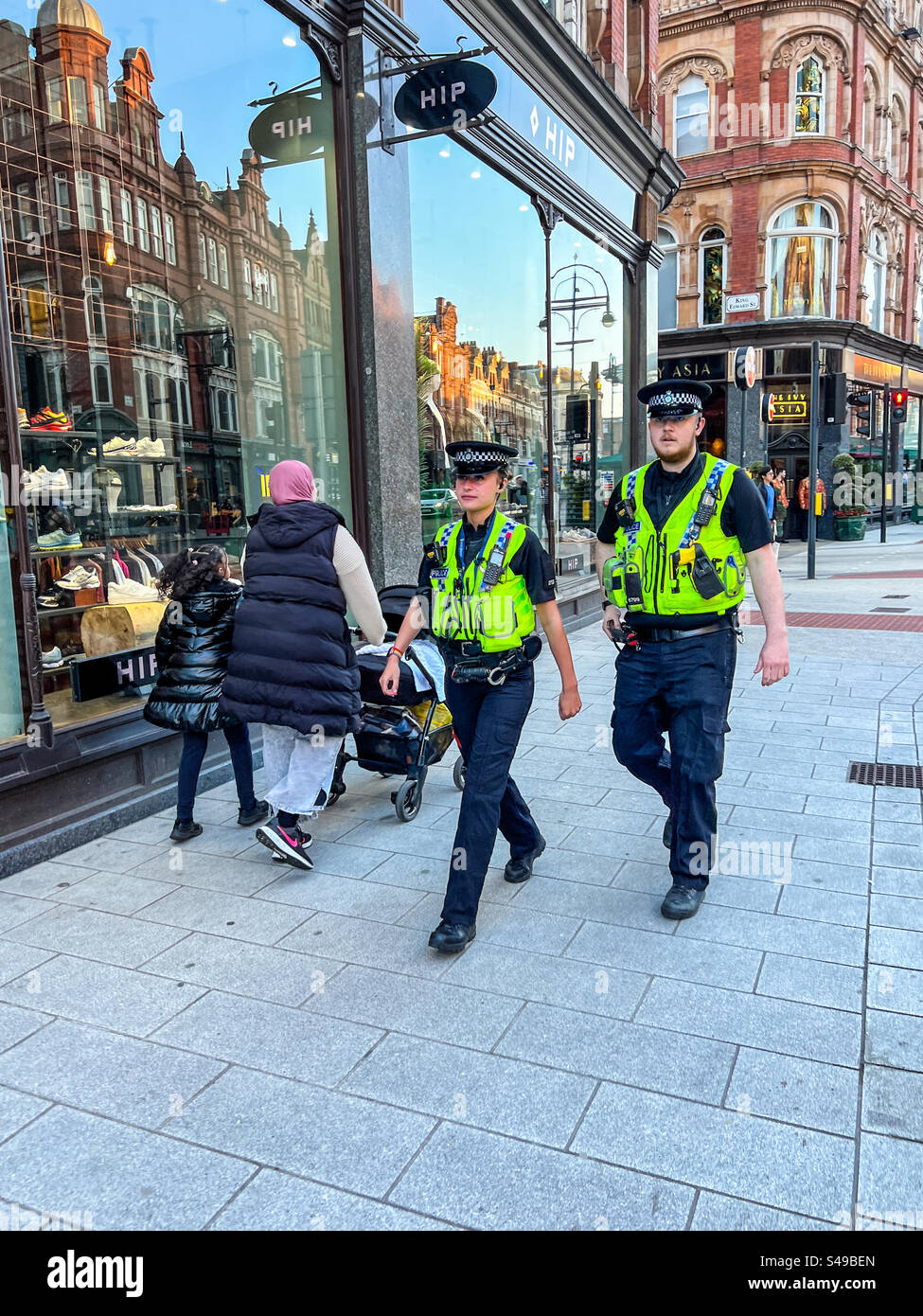 Polizisten gehen die Vicar Lane in Leeds Stadtzentrum entlang Stockfoto
