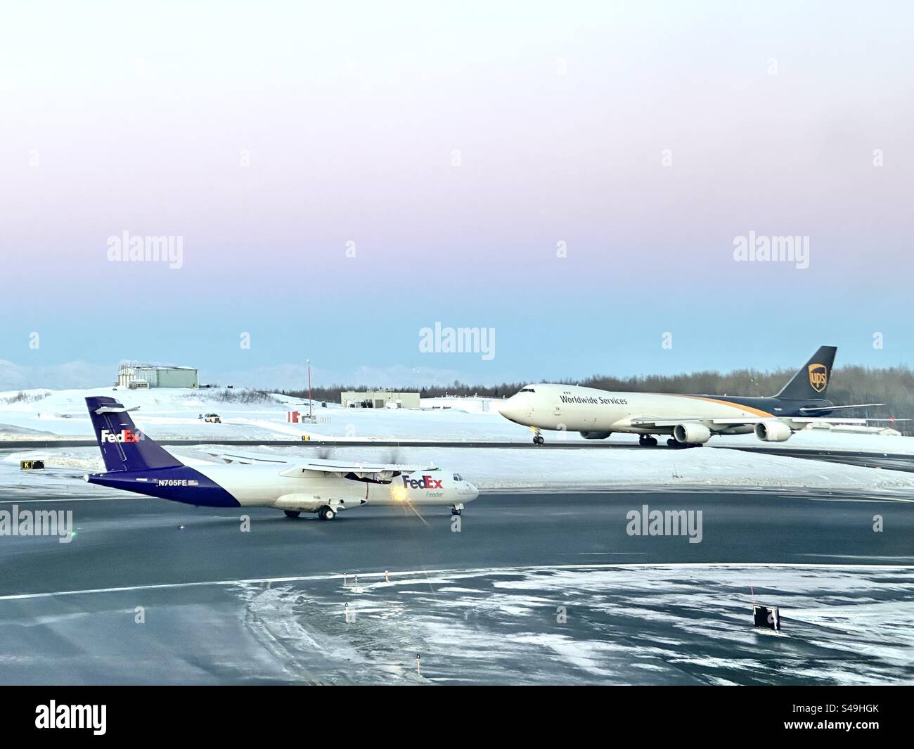 FedEx ATR72-600F und UPS Boeing 747-800 in Ted Stevens, International Airport, Anchorage, Alaska - Smartphone-aufgenommenes Stockfoto