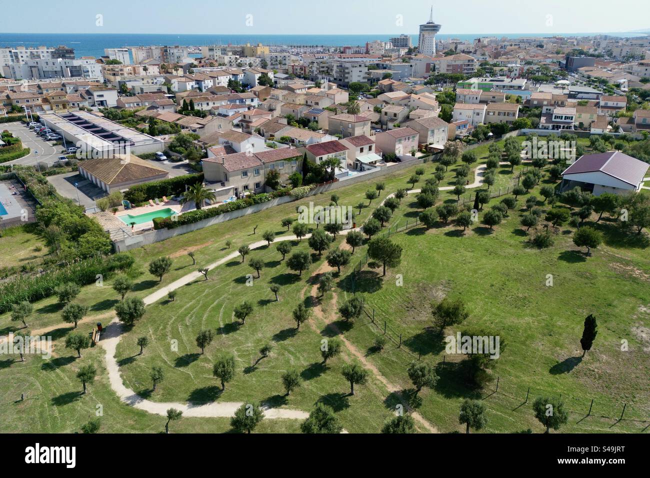 Drohnenaufnahme des Parc du Levant vor dem Hintergrund der Innenstadt von Palavas und der Tour de La Méditerranée in Palavas-les-Flots, Occitanie, Frankreich. Stockfoto