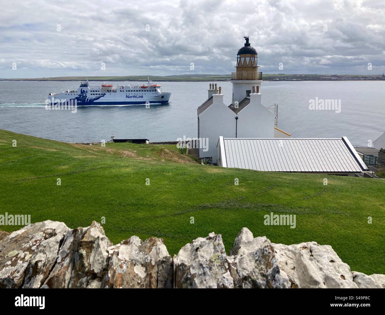 Die Northlink-Autofähre MV Hamnavoe passiert den Leuchtturm Holborn Head, bevor Sie am Hafen von Scrabster an der Nordküste Schottlands ankommen. Sie fährt 6 Mal am Tag von Scrabster nach Stromness auf Orkney. - Smartphone-aufgenommenes Stockfoto