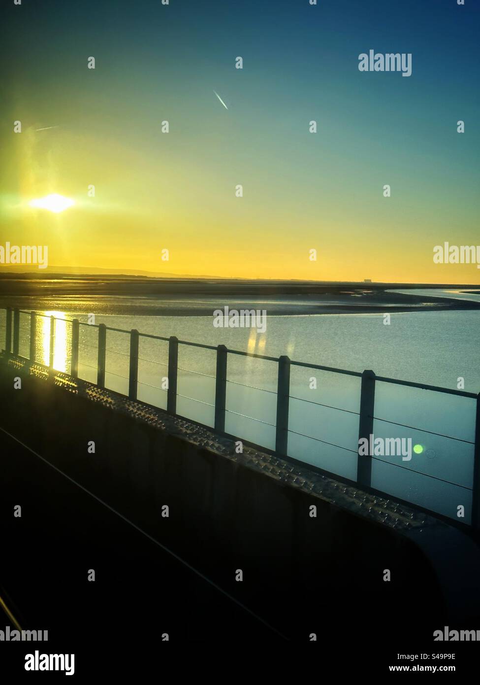 Blick von einem Zug auf eine Brücke über die Mündung Stockfoto