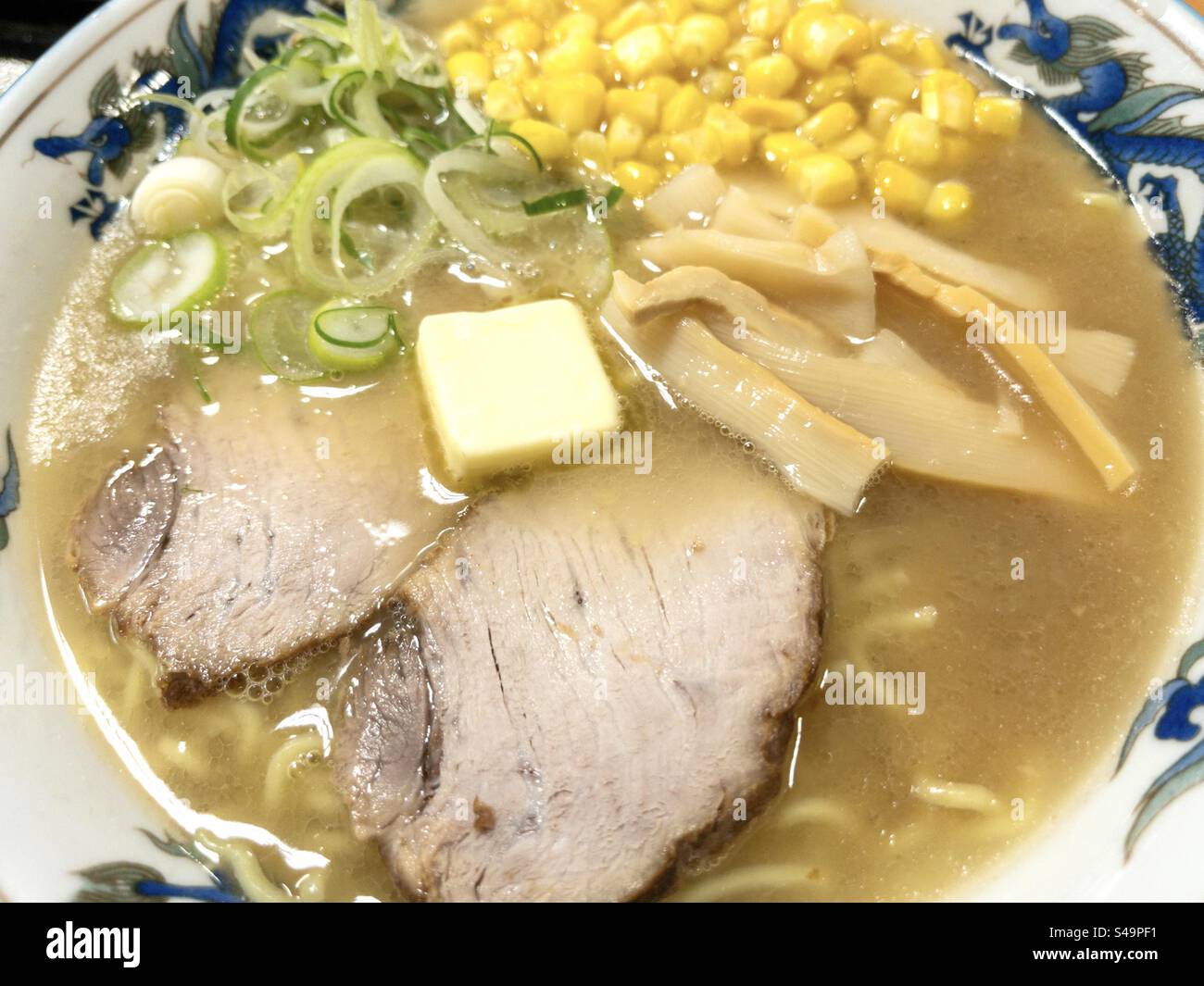 Schüssel mit japanischer Maisbutter Ramen-Nudeln mit Schweinefleisch - Smartphone-aufgenommenes Stockfoto