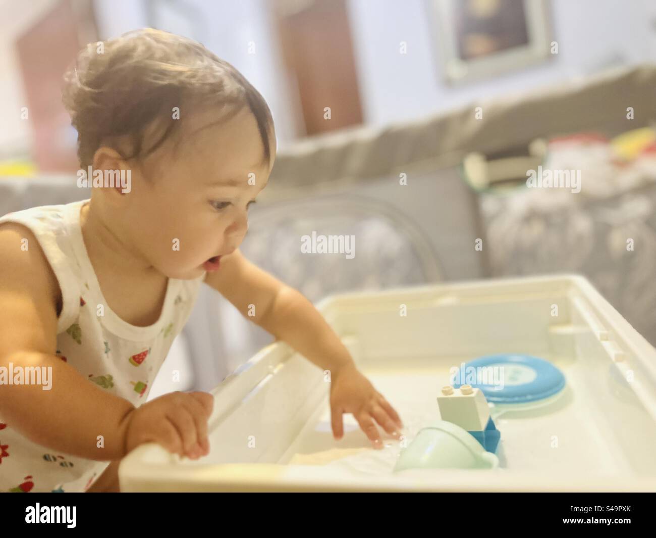 Baby mit Wasser spielen Stockfoto