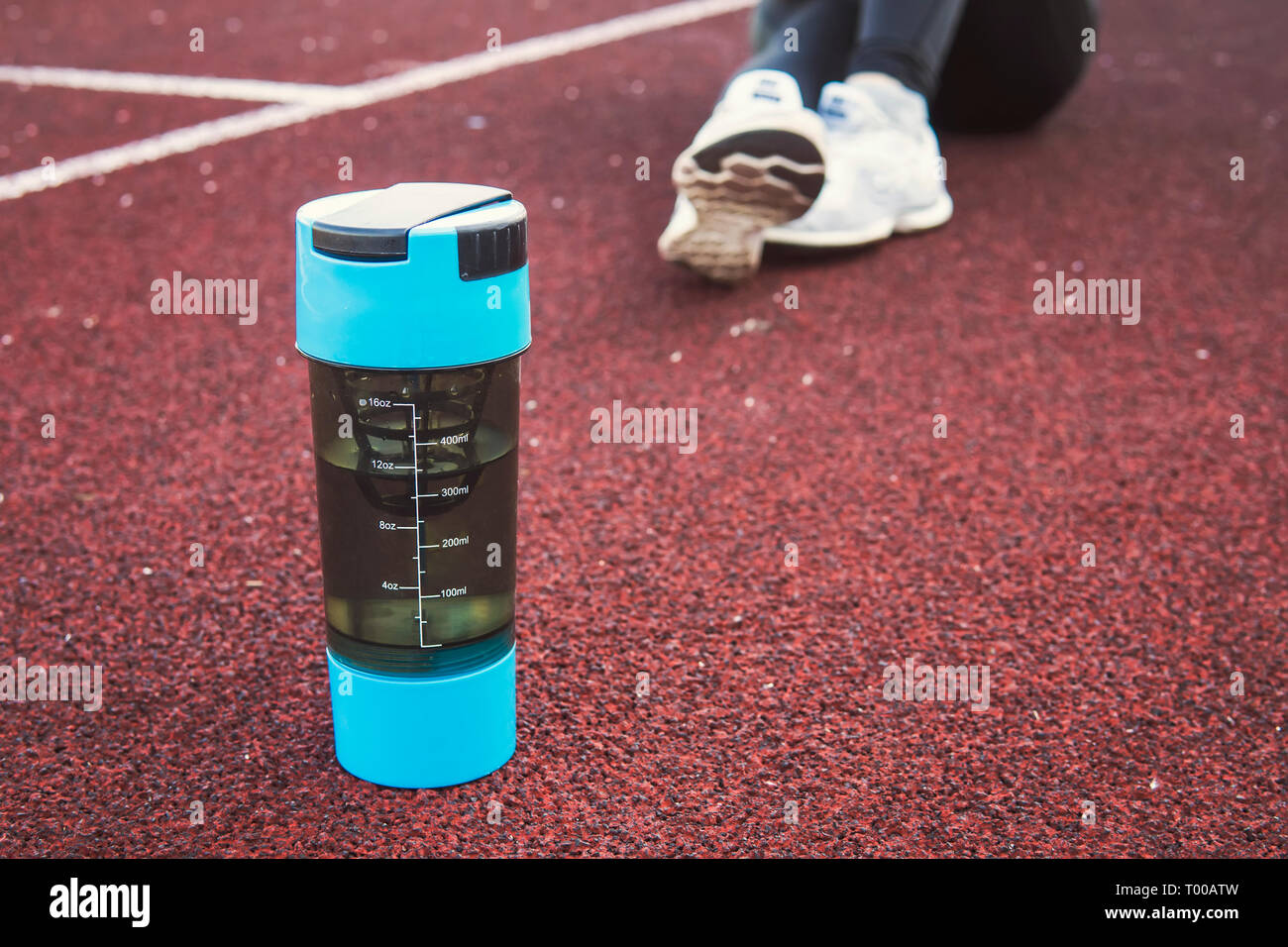 Elegante Flasche für Sport und Fitness mit gesunden Getränken und Wasser auf dem Laufband im Stadion Stockfoto
