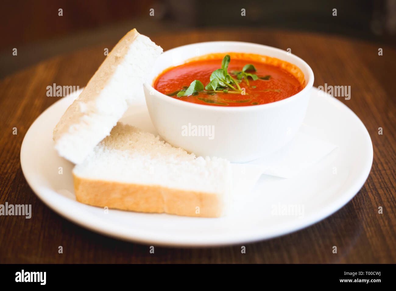 Erwärmung Tomatensuppe mit Scheiben Weißbrot Stockfoto