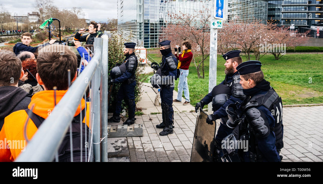 Straßburg, Frankreich - Mar 15, 2019: Polizei sichert durch den Zaun, der von Demonstranten in der Nähe des Europäischen Parlaments während der Demonstrationen gegen den Klimawandel globale Bewegung von Greta Thunberg begann Stockfoto