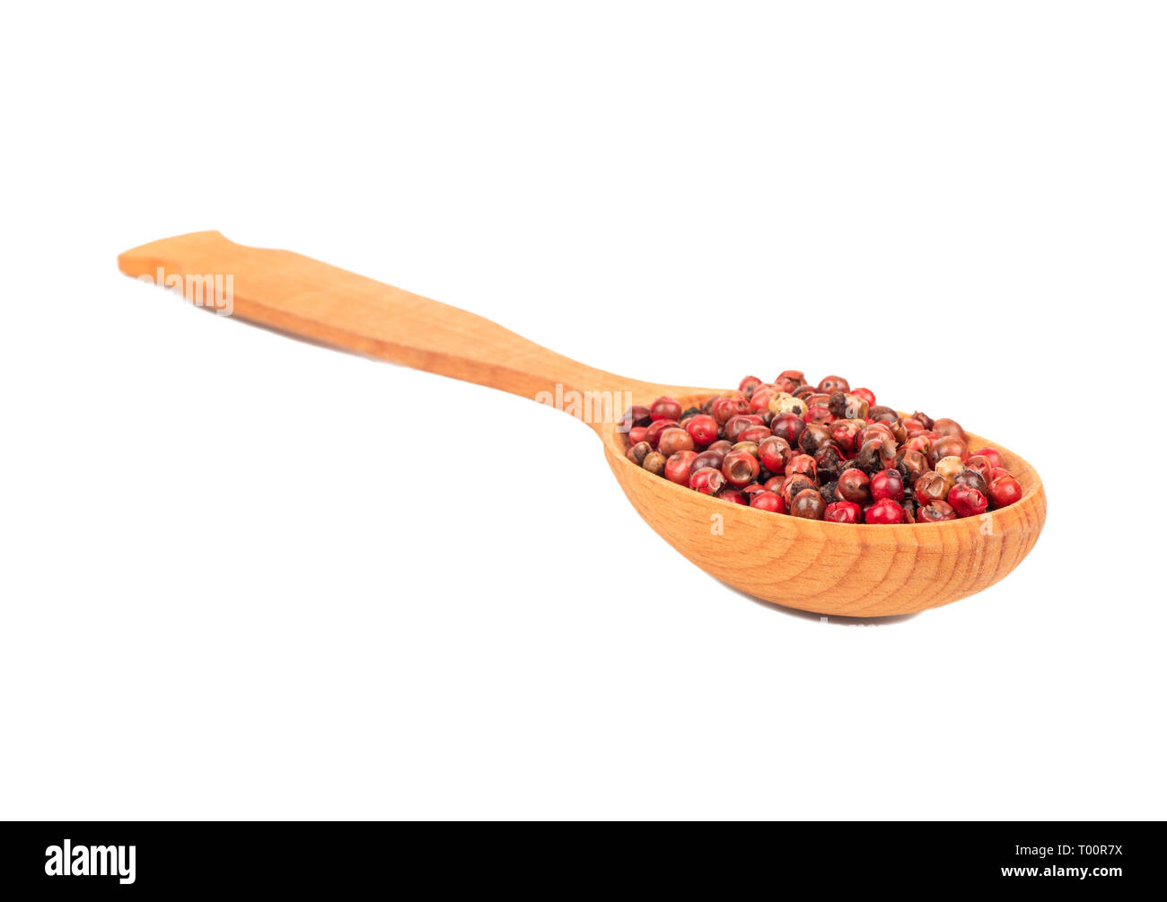 Rote Paprika Erbsen in einem Holzlöffel closeup auf weißem Hintergrund Stockfoto