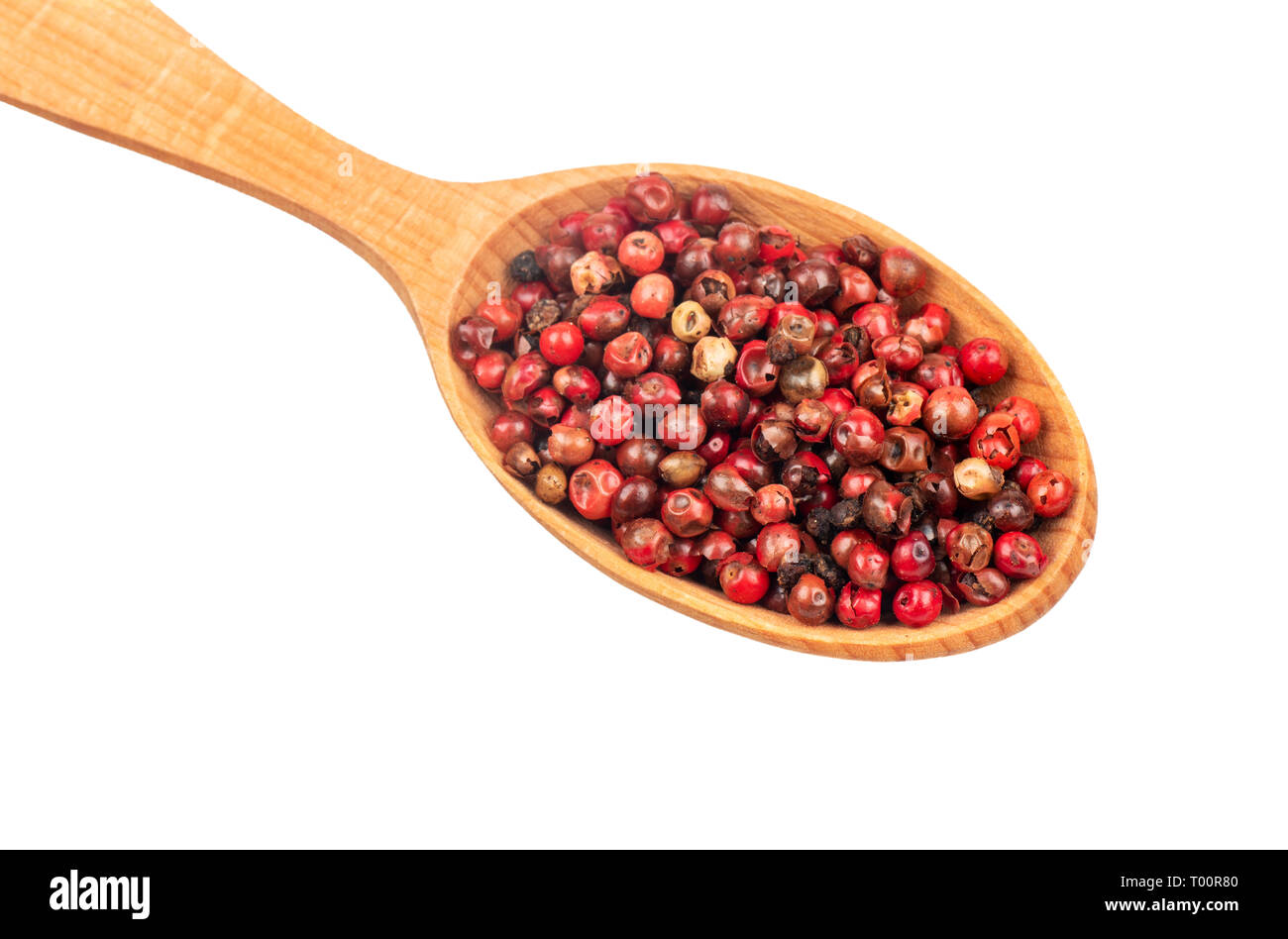 Rote Paprika Erbsen in einem Holzlöffel closeup auf weißem Hintergrund Stockfoto