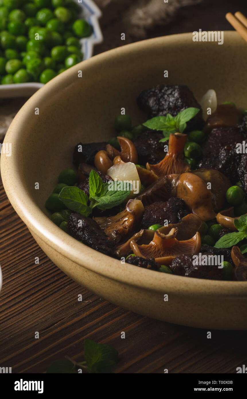 Lecker spicy thai Essen mit Erbsen, Fleisch, Kräuter und Waldpilzen, mit heißer Soße sriracha Stockfoto