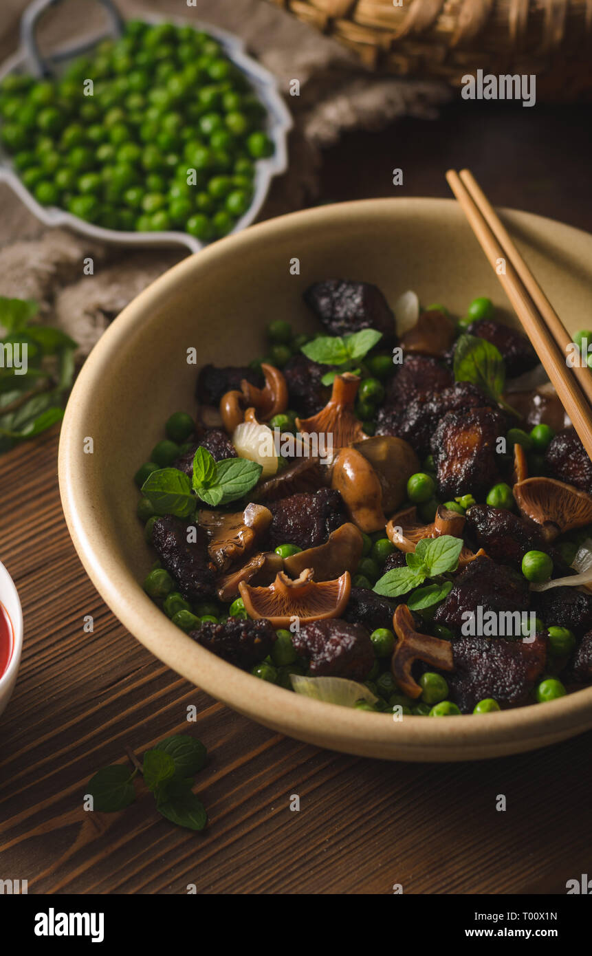 Lecker spicy thai Essen mit Erbsen, Fleisch, Kräuter und Waldpilzen, mit heißer Soße sriracha Stockfoto