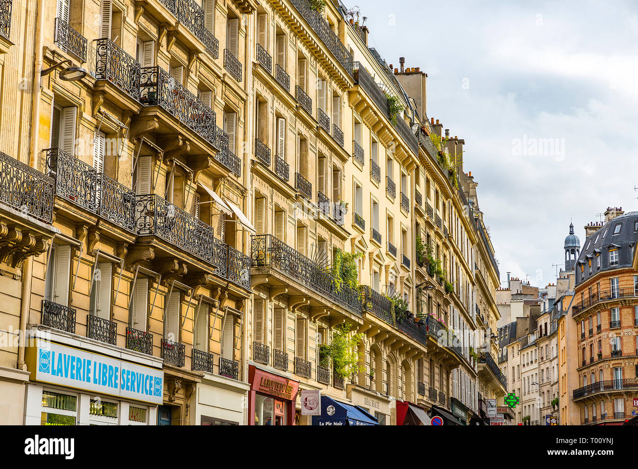 Straße während der Mittagszeit in Paris, Frankreich. Sonnigen Tag mit einigen Wolken und hellem Sonnenlicht. Stockfoto