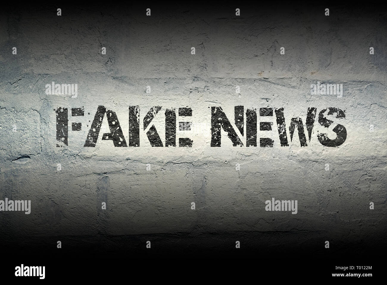 Gefälschte Nachrichten phrase Schablone drucken auf der grunge White Brick Wall Stockfoto