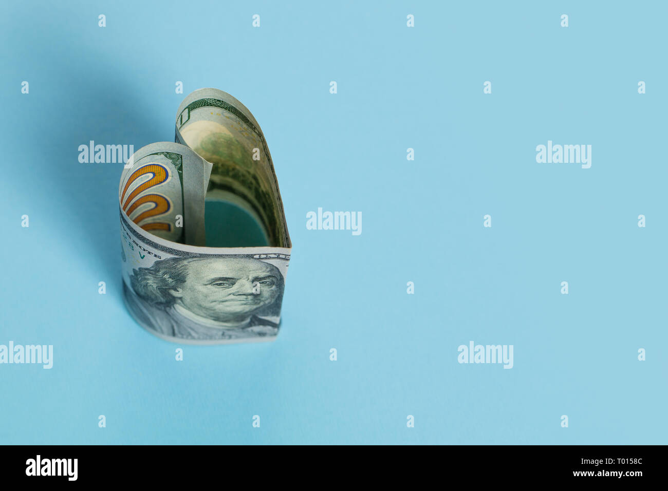US Dollar cash Geld banknote Herzform auf blauem Hintergrund, Darlehen und kommerzielle Geldanlage gewinn Konzept Stockfoto