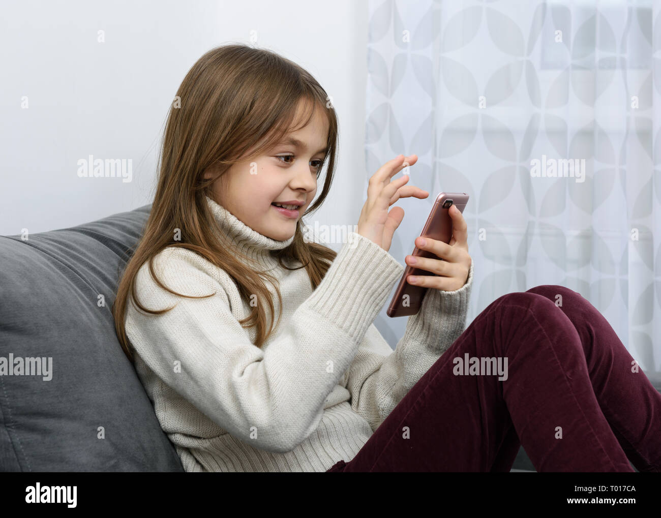 Das junge Mädchen zeigt einen Zeigefinger in ein Smartphone. Stockfoto