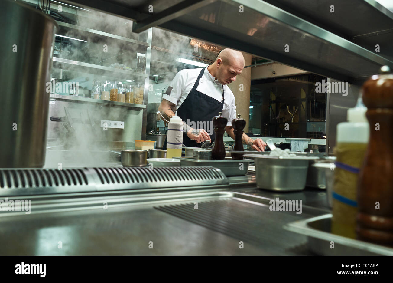 Professionellen Koch. Dem berühmten Küchenchef in schwarze Schürze in einem Restaurant in der Küche arbeiten. Essen Konzept Stockfoto