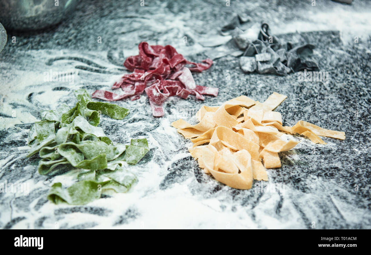 Perfekte arbeit Nahaufnahme von Bunte hausgemachte Pasta liegen auf dem Tisch mit Mehl. Italienisches Essen Stockfoto