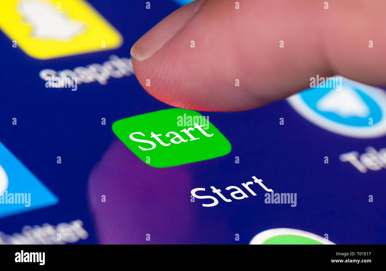 Finger Drücken einer Schaltfläche Start auf einem Touchscreen. Start- oder Anfang Konzept. Stockfoto