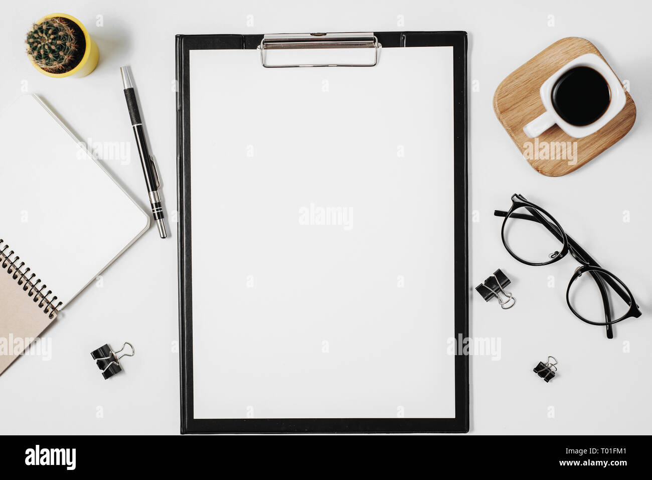 Flach Arbeitsbereich mit leeren Clip Board, Bürobedarf, pen, Kaktus, Kaffeetasse und Brillen auf weißem Hintergrund. Ansicht von oben minimal Mock up Stockfoto