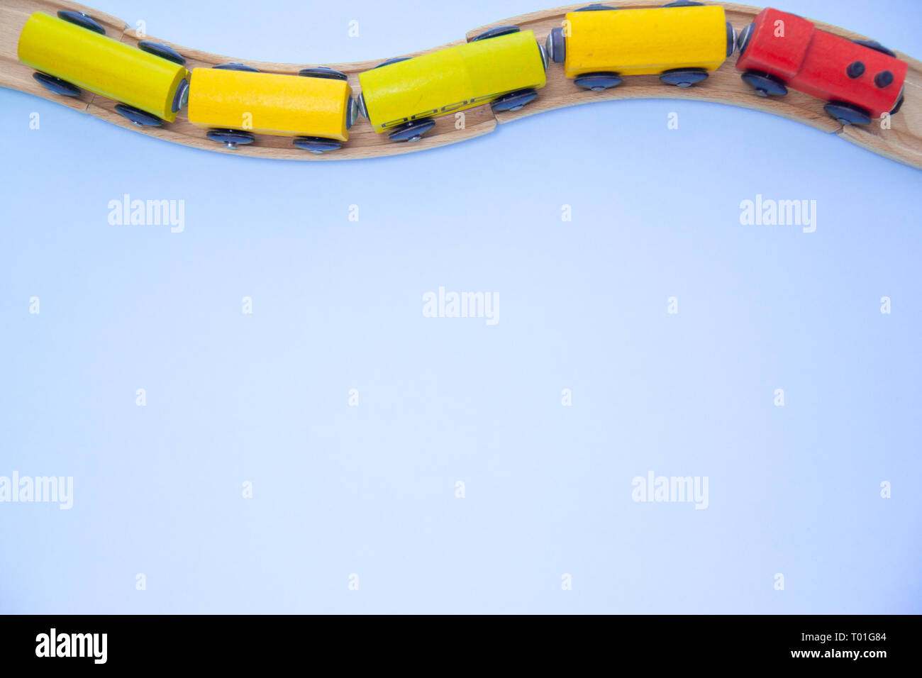 Ansicht von oben über mehrfarbige kinder Waggons Ziegel auf Holz Eisenbahn blauen Hintergrund. Copyspase. Flach. Kinder Spielzeug auf dem Tisch Stockfoto
