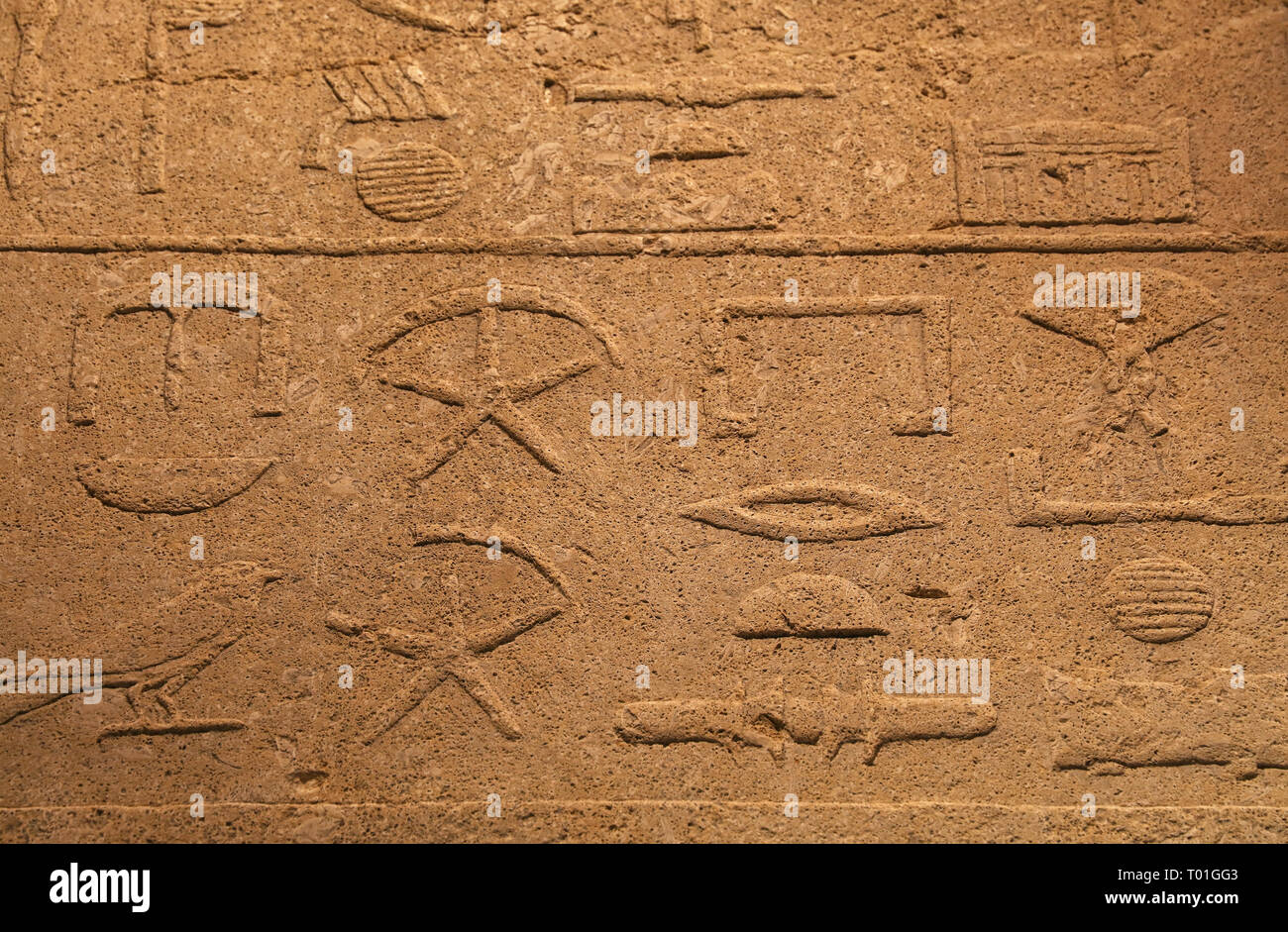 Nahaufnahme Hintergrund der antiken Mauer aus Stein mit geschnitzten antiken ägyptischen Hieroglyphen, Vorderansicht Stockfoto