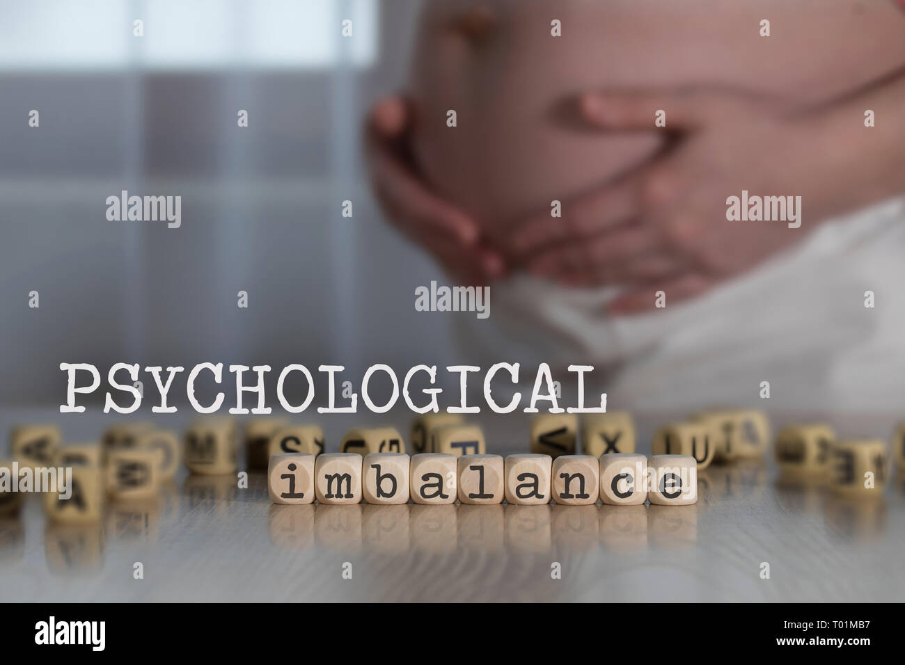 Worte psychologischen Ungleichgewicht aus Holz Buchstaben. Schwangere Frau im Hintergrund Stockfoto