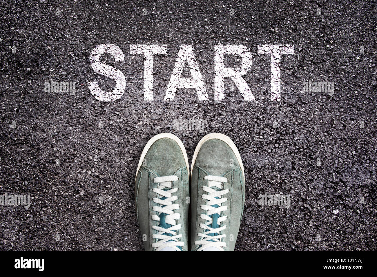 Sneaker Schuhe und das Wort START auf Asphalt Boden geschrieben, neues Leben Konzept Stockfoto