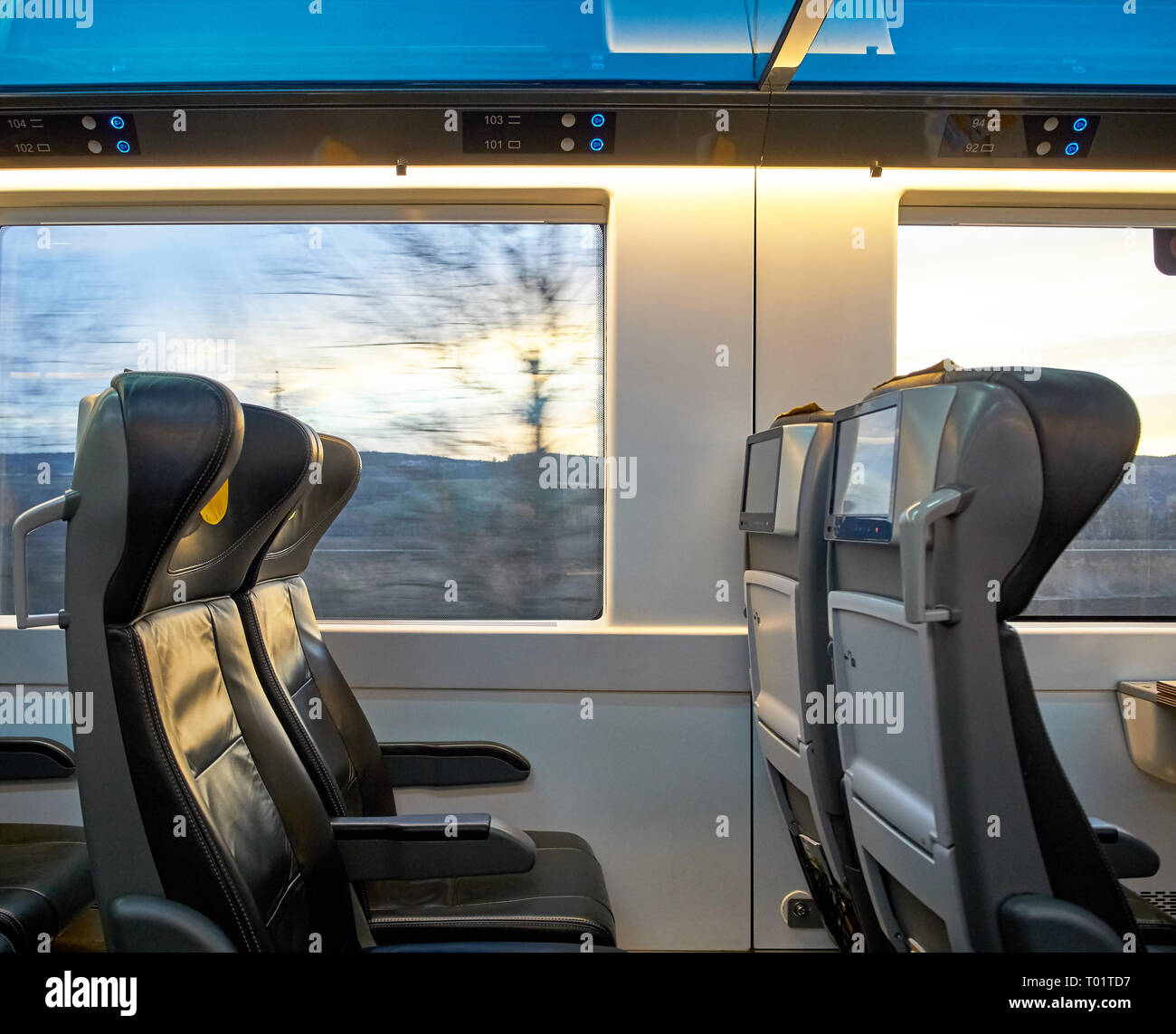 Ansicht der Sitze fahren Zug mit Landschaft vor dem Fenster. Bildschirme und komfortables Reisen. Stockfoto