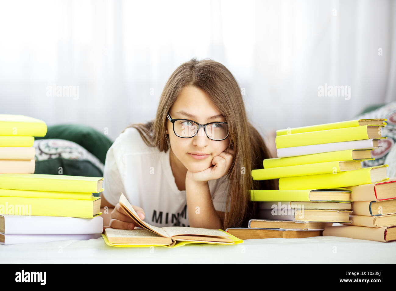 Schöne jugendlich Mädchen ein Buch lesen im Zimmer. Konzept von Bildung, Hobby, Studium und Welttag des Buches Stockfoto