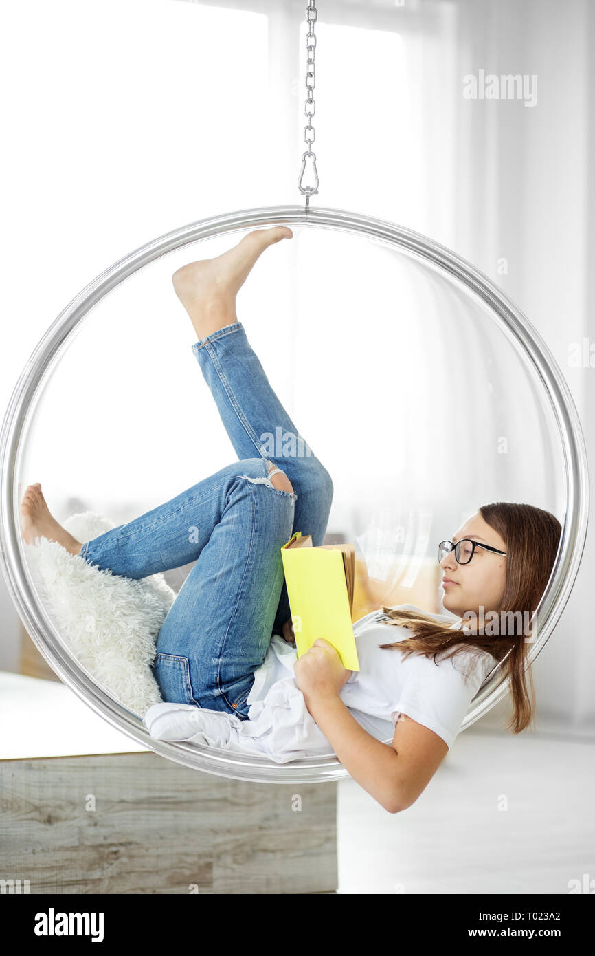 Smart jugendlich Mädchen liest ein Buch im Zimmer. Konzept von Bildung, Hobby, Studium und Welttag des Buches. Stockfoto