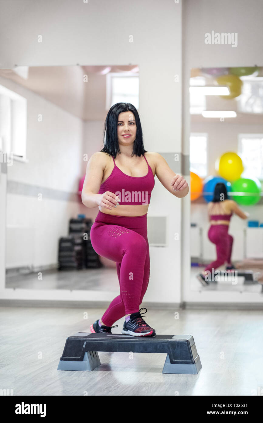 Sportliche Mädchen Züge auf Stepper in der Turnhalle. Das Konzept der Sport, eine gesunde Lebensweise, Gewicht zu verlieren. Stockfoto