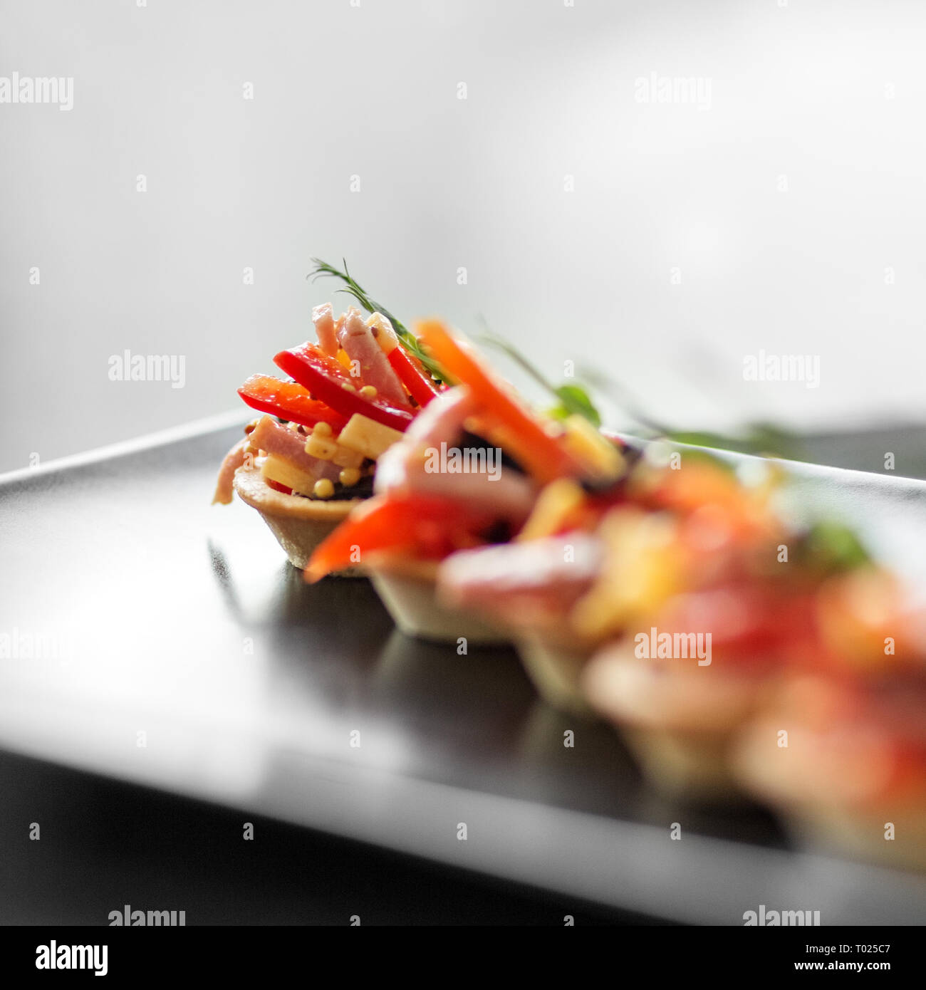 Köstliche französische Snack mit Schinken, Käse, Paprika und Tomate in Törtchen. Konzept der Essen, Restaurant, Catering, Menü Stockfoto