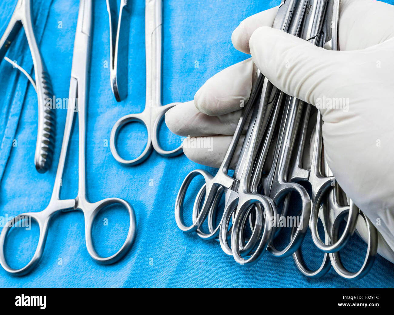 Chirurg im Operationssaal arbeiten, die Hände mit Handschuhen holding Schere Nähte, konzeptionelle Bild, composicon horizontal Stockfoto