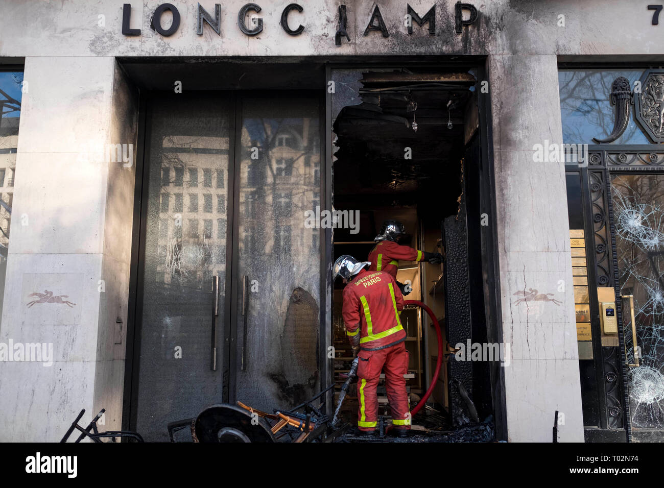 Paris, Frankreich. 16 Mär, 2019. Feuerwehrmänner löschen einen gebrochenen Shop auf der Champs-Elysees avenue in Paris, Frankreich, am 16. März 2019. Französische Polizei mehr als 200 Menschen am Samstag festgenommen Nach der Gewalt in Paris in einem frischen Protest der "Gelbe Weste' Bewegung brach. Credit: Alexandre Karmen/Xinhua/Alamy leben Nachrichten Stockfoto