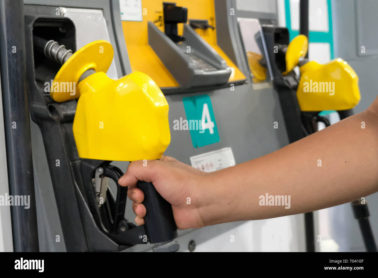Ein Mann gesehen, die den Benzin Düse an einem Petronas Öl und Gas Station in Kuala Lumpur. National Petroleum Limited oder bekannt als Petronas ist eine malaysische Öl- und Gasunternehmen gegründet, am 17. August 1974 und seine durch die Malaysia Staat gehört. Stockfoto