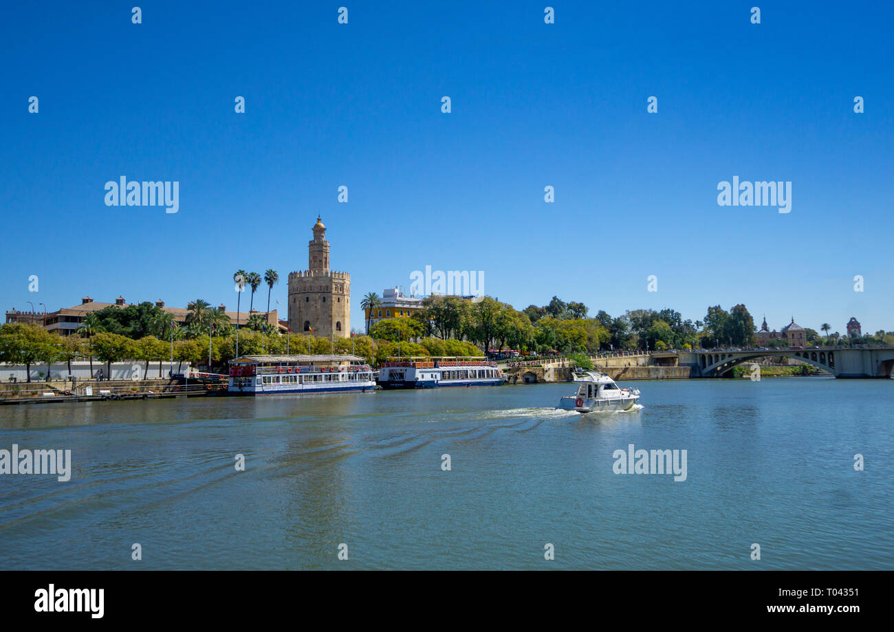 Kleine powerboat​ auf dem Guadalquivir Fluss vorbei an den Turm von Gold in Sevilla Stockfoto