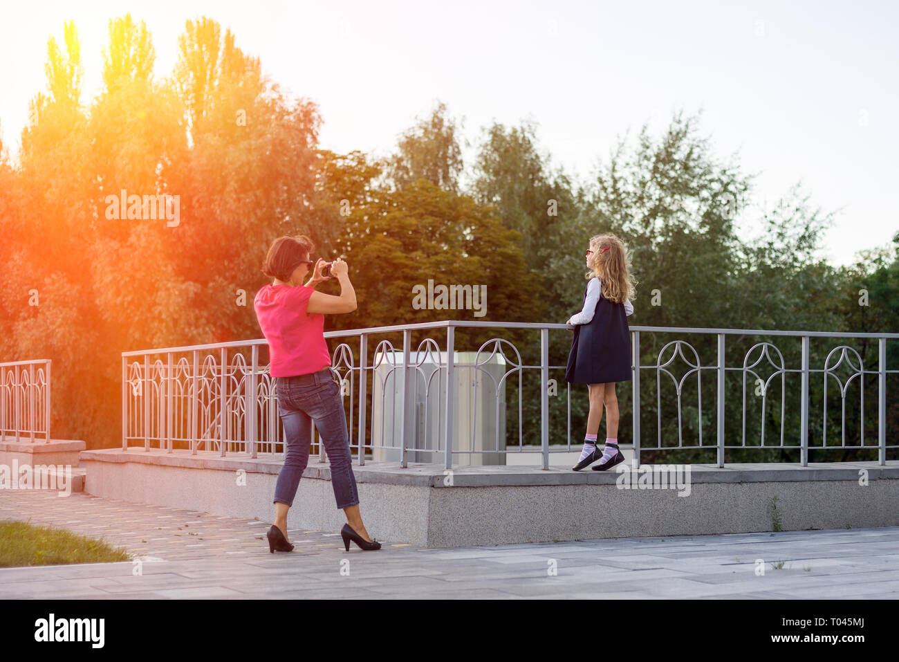 Mutter und Tochter, Liebe und Freundschaft, Mama macht Foto eines Mädchens für instagramme zu Stockfoto
