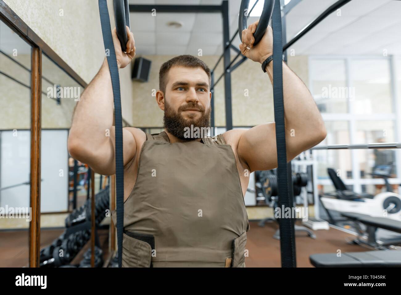 Wehrsport, muskulös kaukasischen bärtige erwachsene Mann Übungen in der Turnhalle gekleidet in einem gepanzerten Bulletproof Vest. Stockfoto